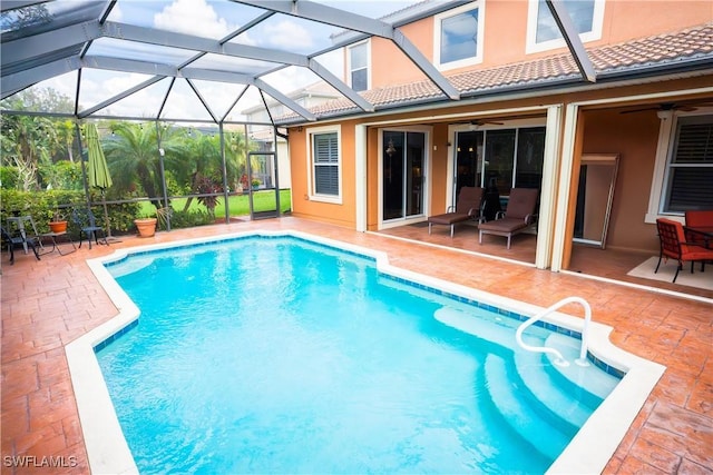 view of swimming pool with ceiling fan, a lanai, and a patio