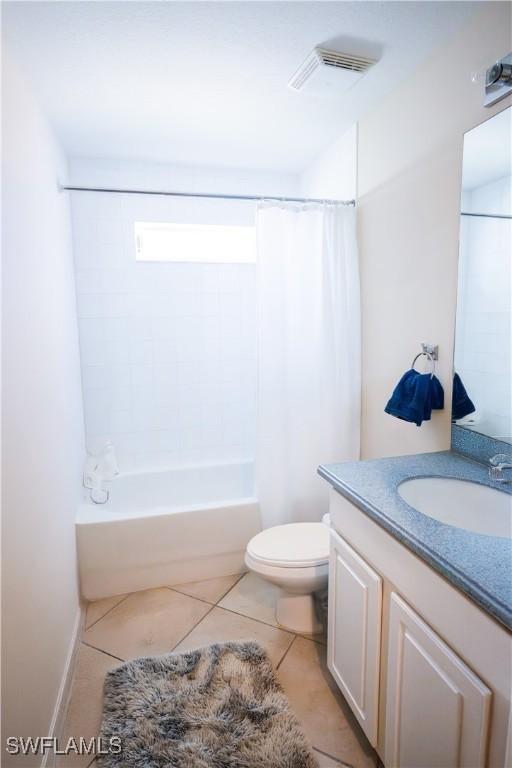 full bathroom featuring tile patterned flooring, vanity, shower / tub combo with curtain, and toilet