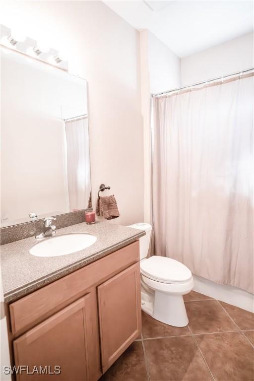 bathroom featuring vanity, toilet, and tile patterned flooring