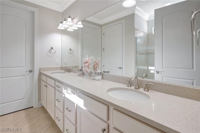 bathroom with vanity, a shower with door, and ornamental molding