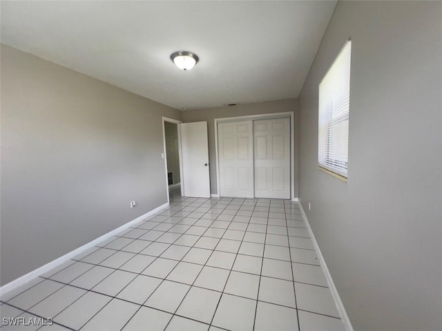 unfurnished bedroom with light tile patterned flooring and a closet