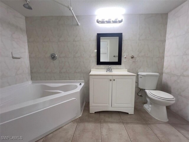 full bathroom with bathing tub / shower combination, tile walls, tile patterned flooring, vanity, and toilet