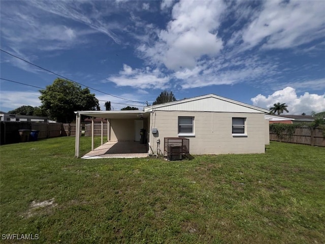 back of house featuring a yard and central AC