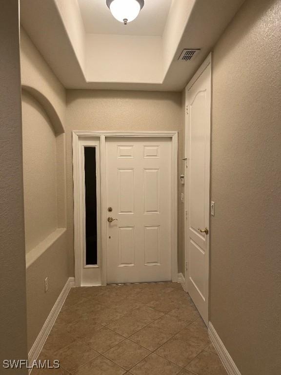 entryway featuring a tray ceiling