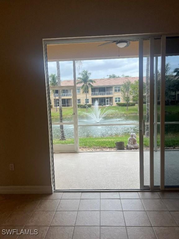 doorway with a water view and tile patterned floors