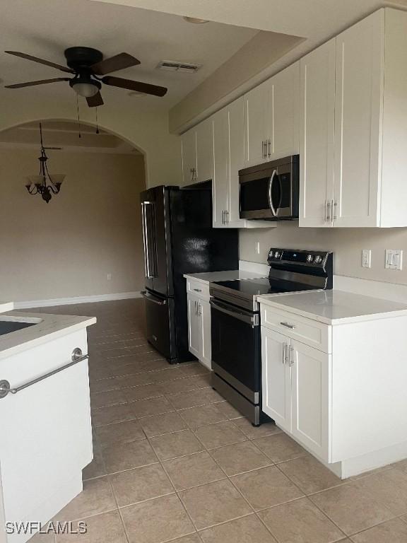 kitchen featuring stainless steel appliances, light tile patterned floors, white cabinets, and ceiling fan