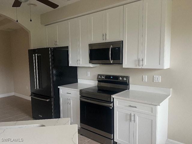 kitchen with ceiling fan, light tile patterned flooring, white cabinets, and appliances with stainless steel finishes