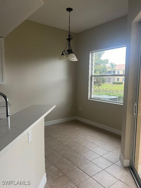 unfurnished dining area with sink and light tile patterned floors