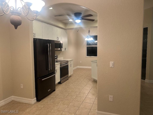 kitchen with ceiling fan with notable chandelier, light tile patterned flooring, white cabinets, and appliances with stainless steel finishes