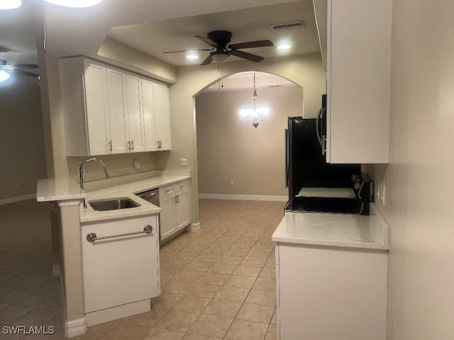 kitchen featuring pendant lighting, ceiling fan with notable chandelier, sink, white cabinets, and stove