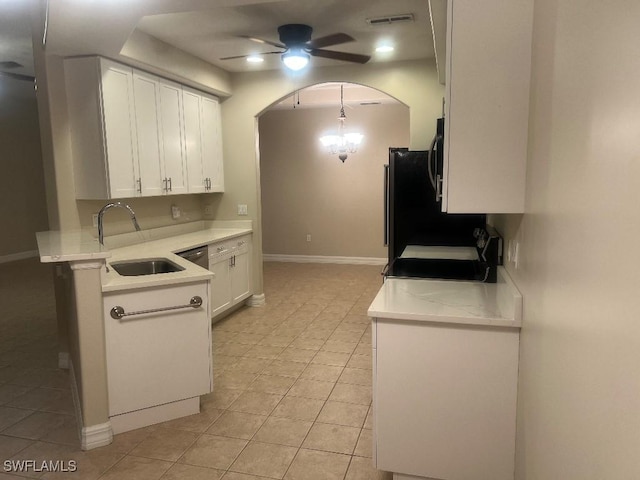 kitchen with light tile patterned flooring, ceiling fan with notable chandelier, sink, white cabinets, and stove