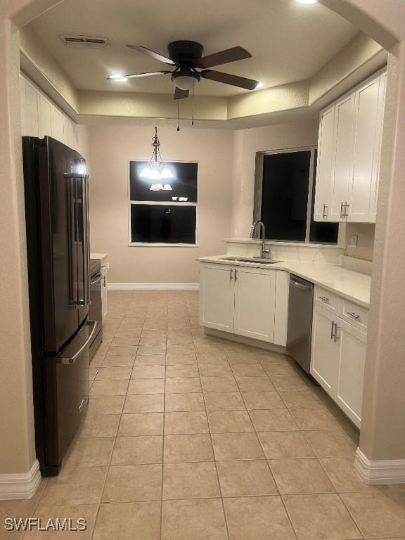 kitchen featuring dishwasher, sink, high quality fridge, and white cabinets