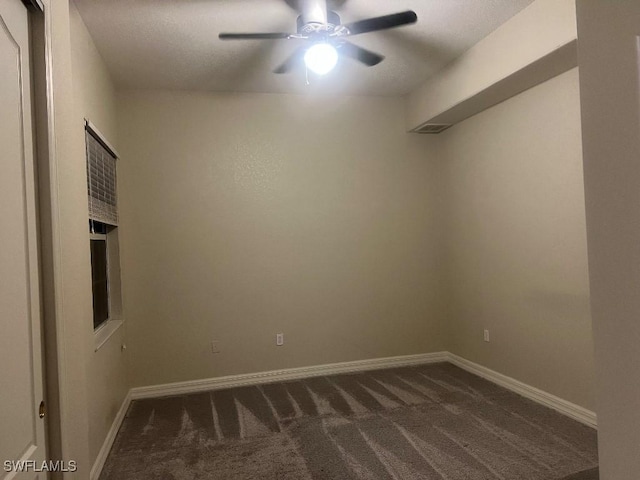 unfurnished room featuring ceiling fan and dark carpet