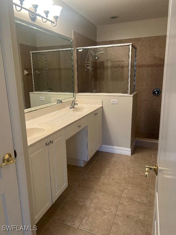 bathroom featuring vanity, a shower with shower door, and tile patterned flooring