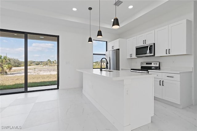 kitchen with a kitchen island with sink, white cabinetry, and appliances with stainless steel finishes