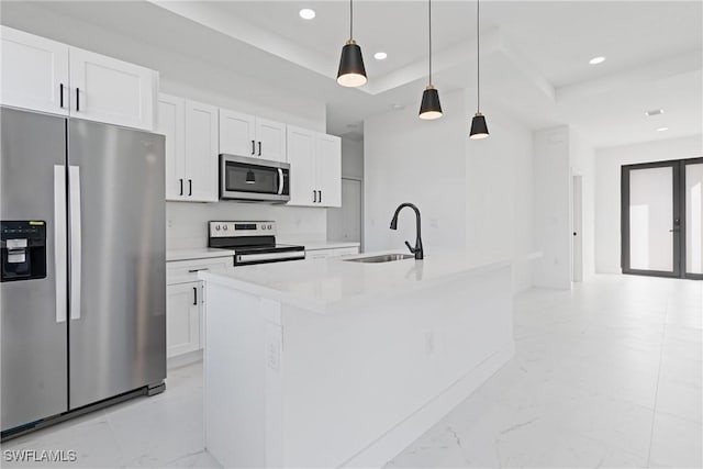 kitchen with pendant lighting, sink, a kitchen island with sink, white cabinetry, and stainless steel appliances