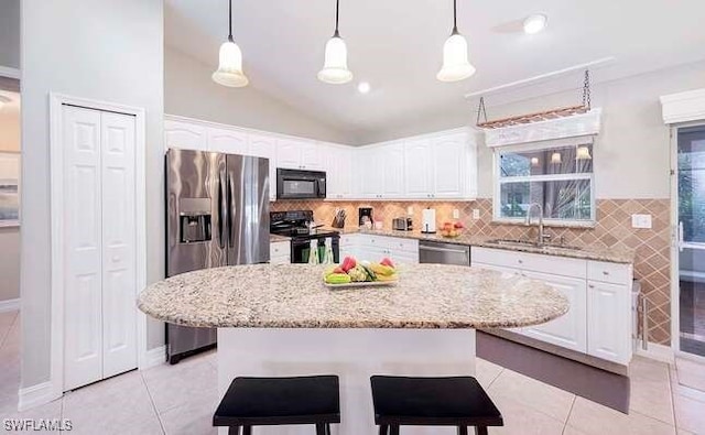 kitchen with hanging light fixtures, a kitchen island, and black appliances