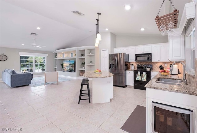 kitchen with sink, hanging light fixtures, black appliances, white cabinets, and light tile patterned flooring