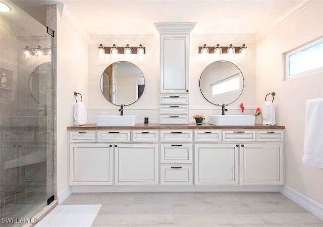 bathroom featuring crown molding, vanity, and a shower with shower door