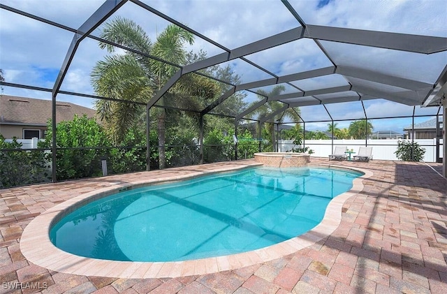 view of pool featuring a patio area, an in ground hot tub, and glass enclosure