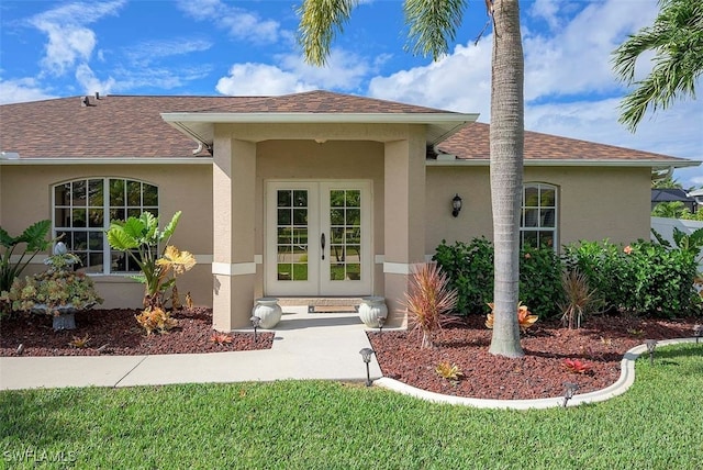 entrance to property featuring a yard and french doors