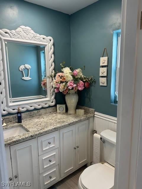 bathroom with vanity, hardwood / wood-style flooring, and toilet