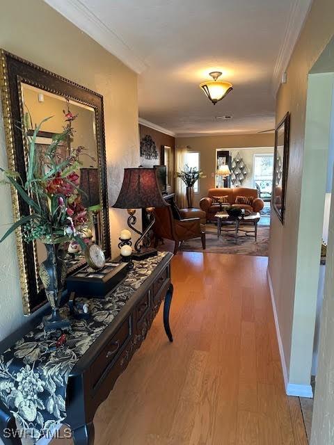 hallway with crown molding and hardwood / wood-style flooring