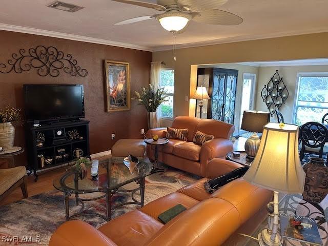 living room featuring crown molding, ceiling fan, and hardwood / wood-style flooring