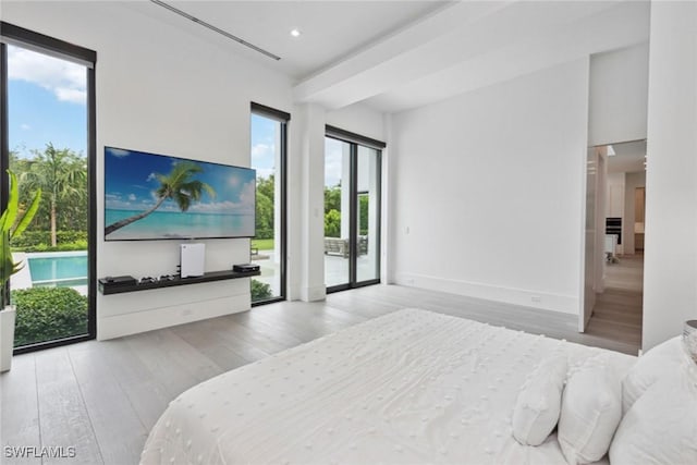 bedroom with access to outside and wood-type flooring