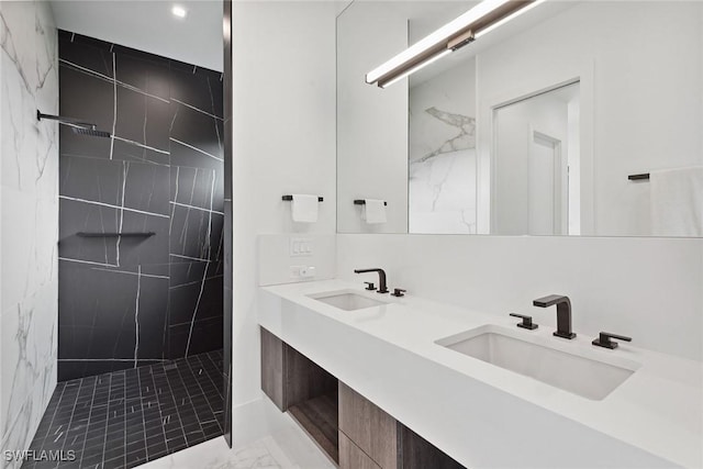 bathroom with tiled shower and vanity