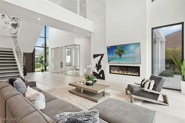 living room featuring a high ceiling and light hardwood / wood-style flooring