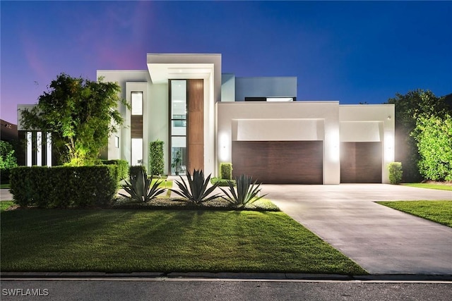 contemporary home with a garage and a lawn