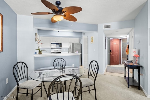 dining area featuring light colored carpet and ceiling fan