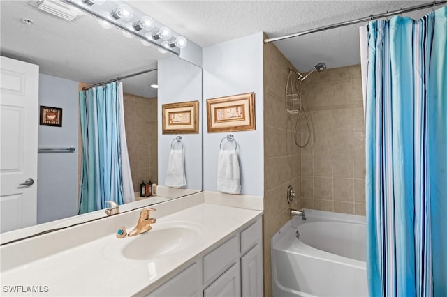 bathroom with shower / tub combo with curtain, vanity, and a textured ceiling