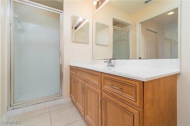 bathroom featuring vanity, a shower with shower door, and tile patterned flooring