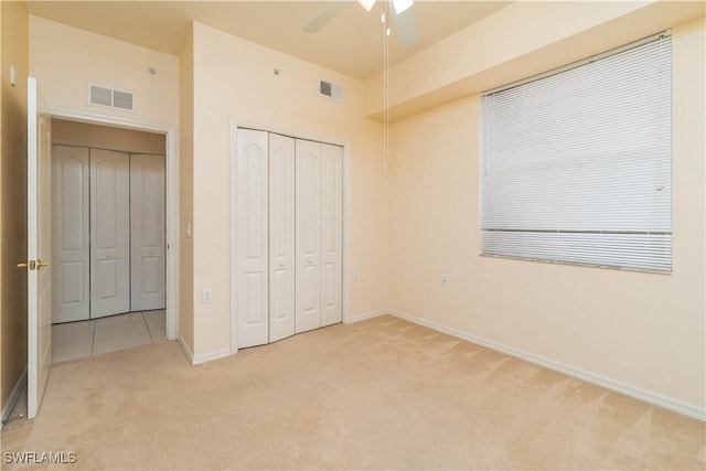 unfurnished bedroom featuring ceiling fan, a closet, and light carpet