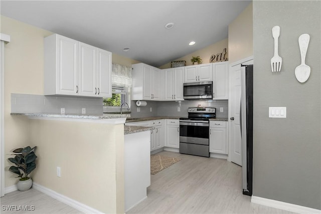 kitchen with sink, white cabinetry, backsplash, stainless steel appliances, and kitchen peninsula