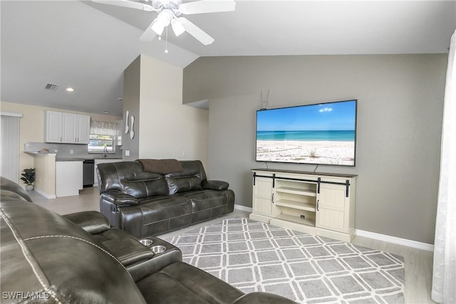 living room with vaulted ceiling, sink, ceiling fan, and light hardwood / wood-style floors