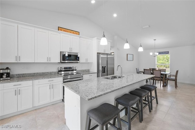 kitchen with sink, hanging light fixtures, stainless steel appliances, an island with sink, and white cabinets