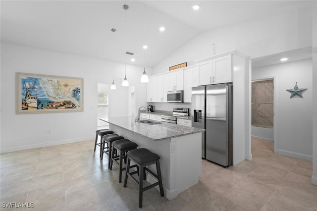 kitchen with appliances with stainless steel finishes, white cabinetry, sink, a kitchen bar, and hanging light fixtures