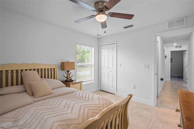 bedroom with light tile patterned floors, a closet, and ceiling fan