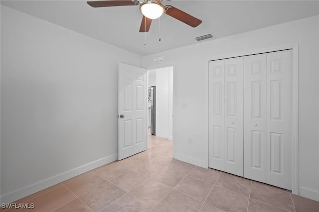 unfurnished bedroom featuring ceiling fan, a closet, and light tile patterned floors