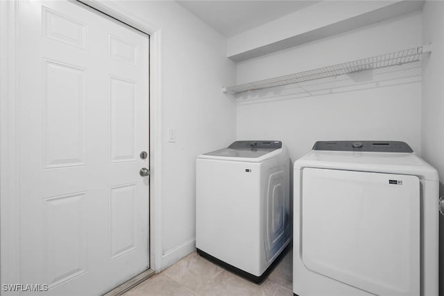 clothes washing area with separate washer and dryer and light tile patterned floors