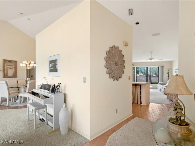 interior space featuring a chandelier, high vaulted ceiling, and light hardwood / wood-style flooring