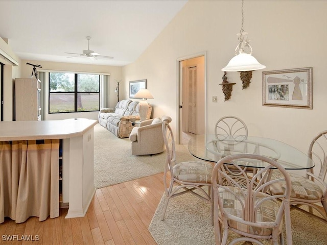 dining room featuring ceiling fan, lofted ceiling, and light hardwood / wood-style floors