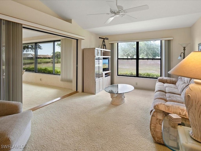 carpeted living room with lofted ceiling and ceiling fan