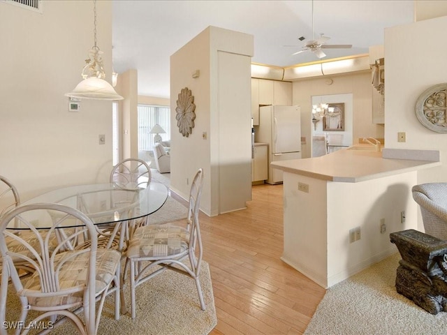 kitchen featuring sink, light wood-type flooring, white refrigerator, kitchen peninsula, and ceiling fan