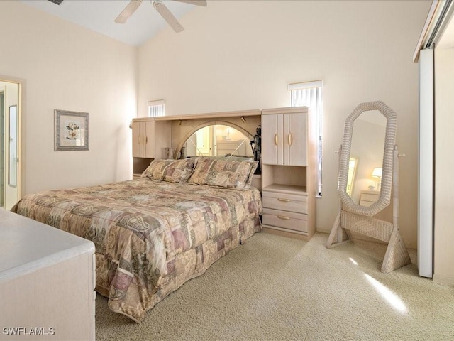 bedroom with ceiling fan, light colored carpet, and vaulted ceiling