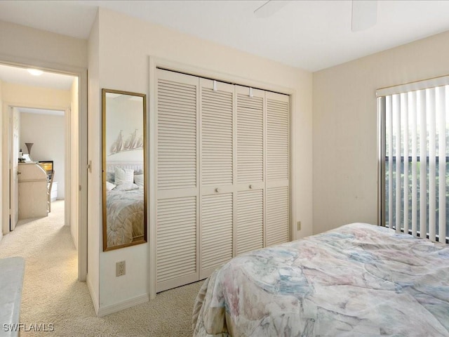 bedroom with light carpet, a closet, and ceiling fan