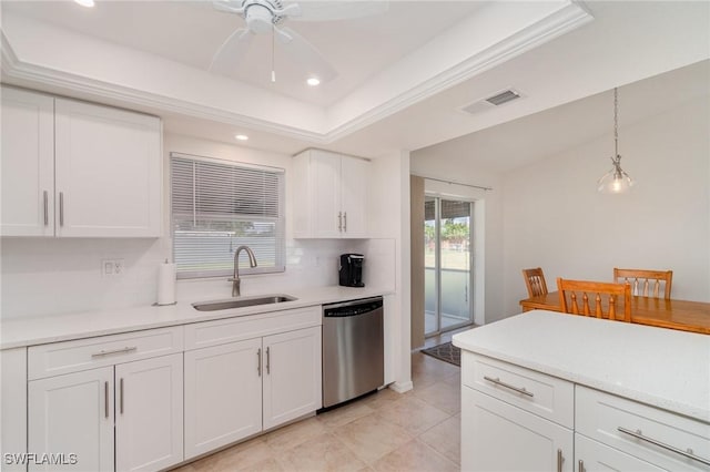 kitchen with sink, stainless steel dishwasher, a tray ceiling, pendant lighting, and white cabinets